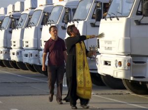 In this image taken from video a Russian Orthodox Church clergyman blesses a convoy of white trucks with humanitarian aid in Alabino, outside Moscow Tuesday, Aug. 12, 2014. The convoy of 280 Russian trucks headed for eastern Ukraine early Tuesday, one day after agreement was reached on an international humanitarian relief mission. But the international Red Cross, which is due to coordinate the operation, said it had no information on what the trucks were carrying or where they were going. (AP Photo/RTR, via Associated Press Television) TV OUT RUSSIA OUT